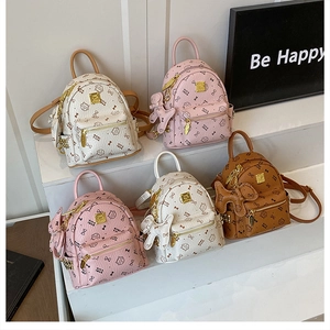 Detail showing five mini cat-themed backpacks with plush pendants and gold zipper hardware