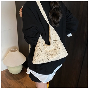 Close-up of cream crochet tote bag with hollow knit patterns and triangle structure