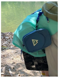Détail d'un sac bandoulière bleu en nylon avec logo de montagne et sangle réglable