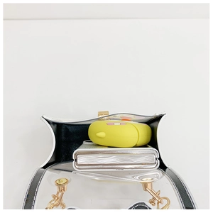 Détail du mini sac en PVC transparent montrant la capacité intérieure et chaîne dorée