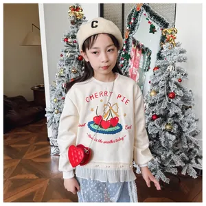Détail d'un sweat crème pour fille avec ourlet en tulle et perles décoratives