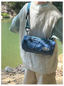 Détail du sac bandoulière cylindrique bleu avec cordon élastique et sangle réglable