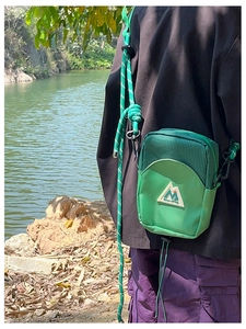 Détail de la mini sacoche verte style outdoor pour enfant avec nylon et bandoulière en corde