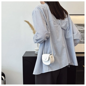 Close-up of white heart-shaped crossbody bag with embossed texture and thin shoulder strap