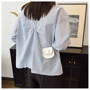 White heart-shaped mini crossbody bag shown on model back for scale and style