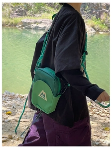 Détail du sac bandoulière d'extérieur vert avec texture mesh et sangle en nylon