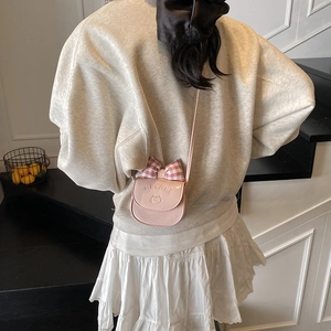 Pink mini crossbody bag with plaid bow and cat embroidery shown on a model