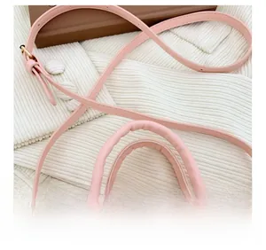 Detail of pink stone-patterned handbag showing soft padded handles and adjustable strap