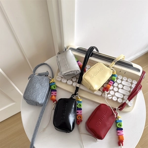 Mini neck pouches for kids in five vibrant colors displayed on a white round table