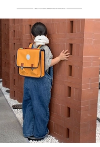 Détail du sac à dos vintage jaune avec poignée arc-en-ciel et sangles en cuir brun