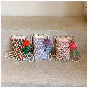 Gros plan de mini sacs tulipes crochetés main en 3 coloris avec breloques fleurs