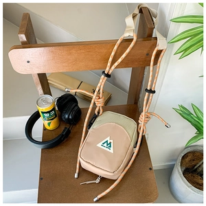 Détail du petit sac bandoulière enfant avec cordon orange et écusson de montagne brodé
