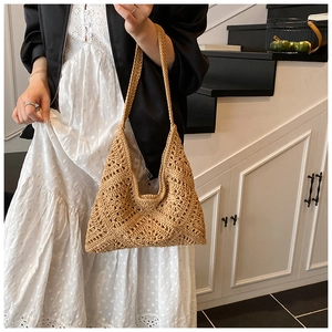 Detail of bohemian crochet shoulder bag with intricate geometric cutout knit texture