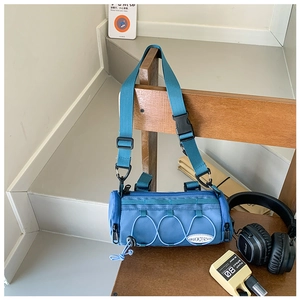 Détail du sac à bandoulière bleu cylindrique avec cordon élastique et nylon robuste