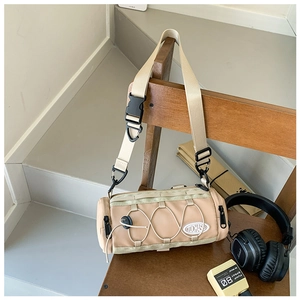 Détail du sac bandoulière cylindrique kaki avec cordons élastiques et sangle pour enfants