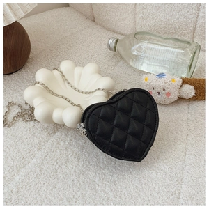Détail du mini sac en forme de cœur avec cuir matelassé et bandoulière chaîne