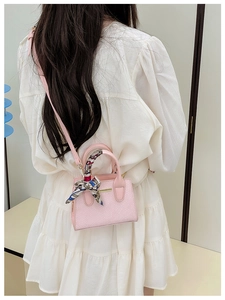 Detailed pink snakeskin pattern handbag with elegant silk scarf wrap on the handle