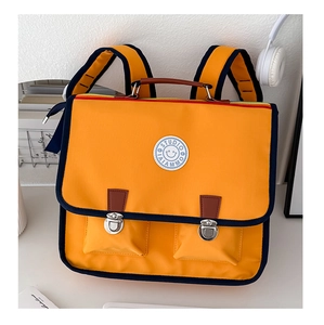 Détail du cartable orange style britannique avec poches à boucles et bretelles rembourrées