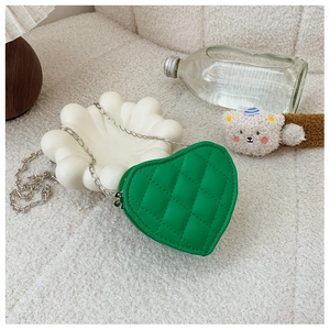 Détail du mini sac matelassé vert en forme de cœur avec élégante bandoulière chaîne argent