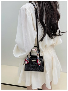 Detail of black faux leather mini bag with silk scarf handle and stone pattern