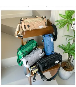 Détail de sacs bandoulière cylindriques en nylon en cinq couleurs sur chaise vintage