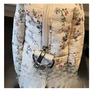Detailed close-up of smooth silver zipper and floral quilted fabric on the large diaper bag