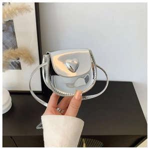 Close-up of silver heart-shaped metal buckle on a trendy metallic crossbody bag for kids