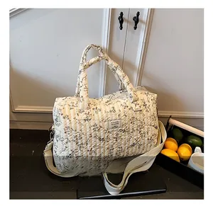 Quilted floral travel bag detail showing the cream fabric and detachable wide strap