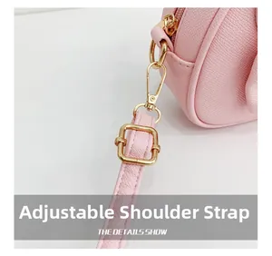 Détail de sac à main en cuir synthétique rose avec boucle métallique dorée réglable
