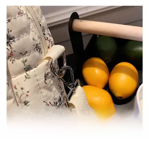 Detail of the high-quality metal swivel hook and floral quilted fabric on the diaper bag