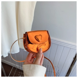 Detailed view of the vibrant orange heart-shaped mini crossbody bag with glossy metallic finish