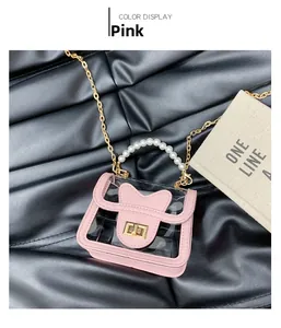 Sac gelée rose transparent avec poignée en perles et chaîne dorée sur fond noir