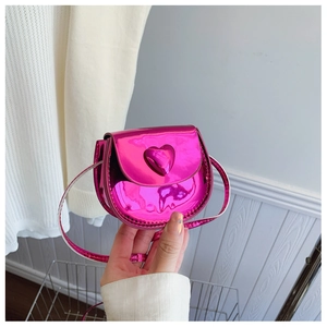 Detail of metallic pink heart-shaped mini crossbody bag with embossed heart and long strap