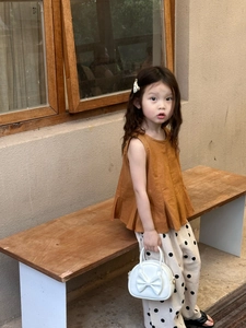 Détail d'un mini sac à main blanc avec un joli nœud pour fille, idéal pour l'été frais