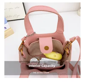 Capacità interna della mini borsa in pelle rosa con cosmetici e dettagli in oro retrò