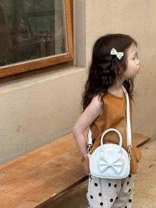 Vue détaillée du sac blanc pour fille avec nœud papillon et bandoulière amovible