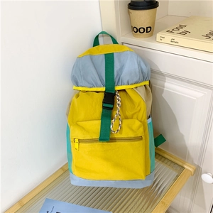 Detailed view of colorful drawstring backpack with buckle and mesh side pocket