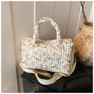 Detailed close-up of quilted floral diaper bag with cotton fabric texture and shoulder strap