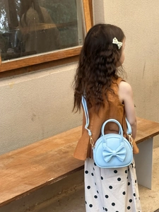 Détail du sac bandoulière enfant bleu clair avec grand nœud et bandoulière ajustable