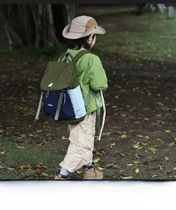 Outdoor shot of kid wearing the multi-pocket color-block nylon backpack in park
