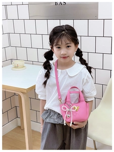 Dettaglio della mini borsa rosa con fiocco di perle e tracolla regolabile per bimba