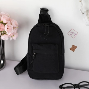 Détail du sac de poitrine noir pour enfants avec sangle ajustable et poche avant zippée