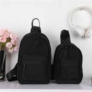 Détail de deux sacs de poitrine en nylon noir de tailles différentes avec cordons