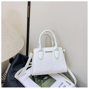 Detail showing the white snake pattern texture and gold metal buckle of this mini handbag