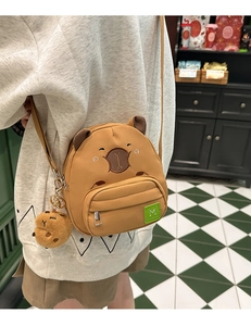Détail du sac à bandoulière capybara en peluche avec broderie et petit porte-clé