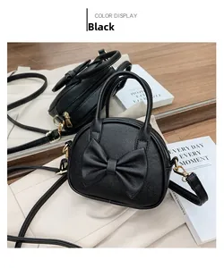 Gros plan sur un sac à main noir pour enfant avec nœud et crochets en métal doré
