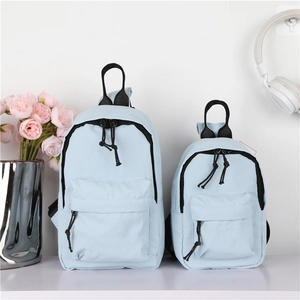 Détail d'un ensemble de sacs à dos en nylon bleu clair en grandes et petites tailles
