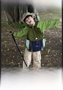 Outdoor lifestyle shot of a durable kids hiking backpack in army green and blue colors