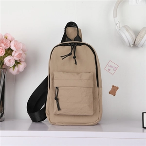 Détail d'un sac de poitrine enfant en nylon kaki avec sangle réglable sur étagère