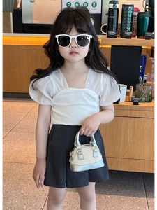 Fillette portant un mini sac à main tressé argenté élégant avec haut à manches bouffantes